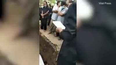 Dead person in coffin appears to wave hand to mourners
