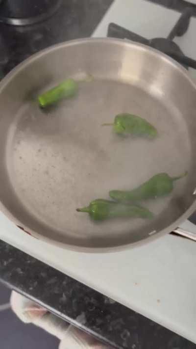 WCGW putting wet chillies in a hot scotching hot pan while recording a cooking video