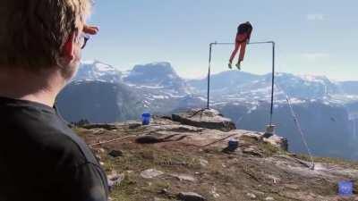 WCGW Swinging on a bar on the edge of a cliff