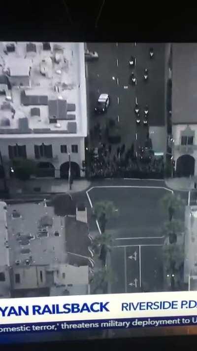 Riot cops in line attack parked car.