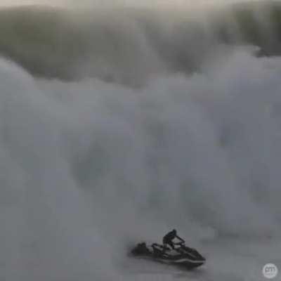 Surfer gets rescued before a gigantic wave hits