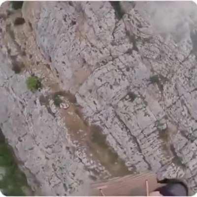 This mental idiot who uses an attachment connected to a tight rope between 2 mountains.