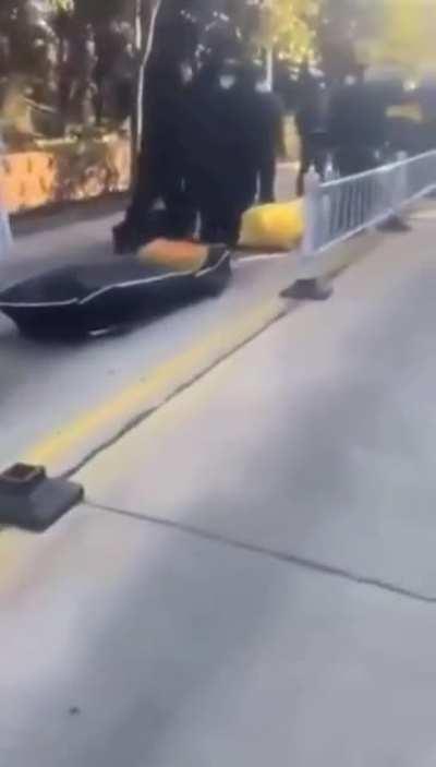 Long line of bodies lying on the street in China waiting to be cremated