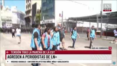 Los zurdos siempre atacando por la espalda. Agreden a notero mientras entrevista a una mujer que denuncia haber sido herida por los policias.