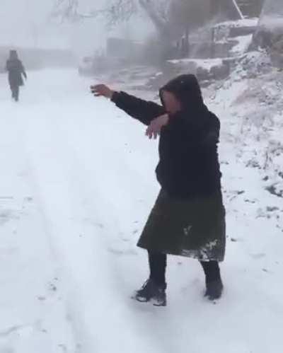 Babushkas calling for their friend to come out and play in the snow