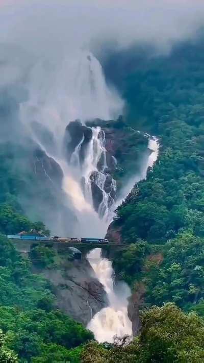 Indian Railways train passing through Dudhsagar Falls, Goa