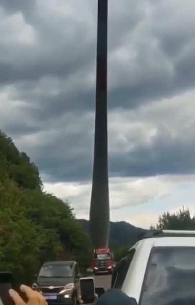 Moving a very large object on a mountain road.