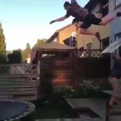 Jumping towards a trampoline from a ladder.