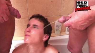Two old fucks pissing on young slut in bathtub. 