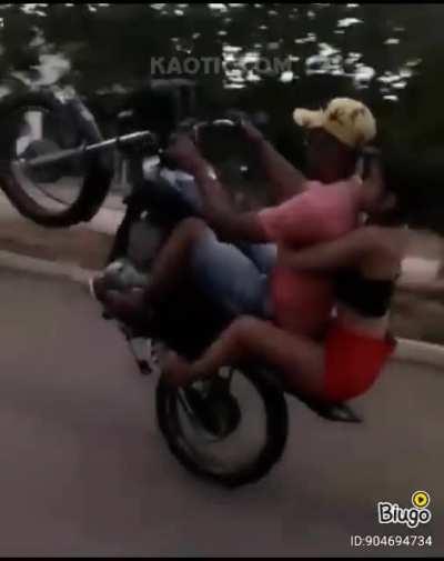 Doing a wheelie with a girl at the back