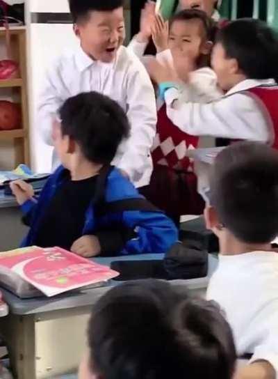 Young man gets 100% on an assignment. Classmates are amped for him