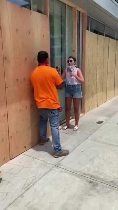 This lady stopped someone boarding up a store in Santa Monica so she could hold the drill for a picture