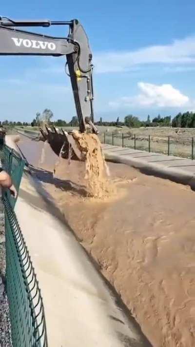 A cow drifting in a canal saved by an excavator. IÄdÄ±r, Turkiye