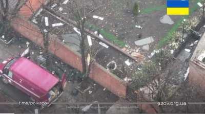 Ukrainian soldier throws grenades over a wall at Russian soldiers as they load looted valuables onto a van. Mariupol 2022