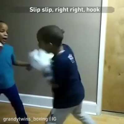 This boy is coaching his twin brother in boxing.