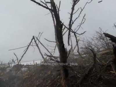 Ukrainian soldier in a trench shoots a Russian soldier approaching their position