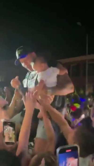 Woman crowd surfs baby at Flo Rida concert