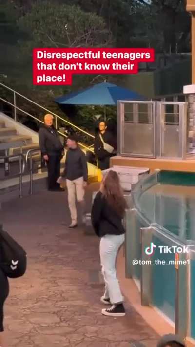 Teenagers interrupt a mime's performance