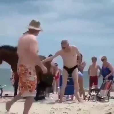 Trying to pet a wild horse on the beach
