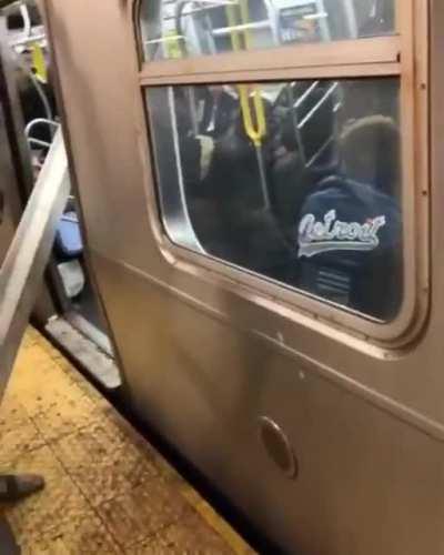 New yorkers help a man get a steel beam on the train.