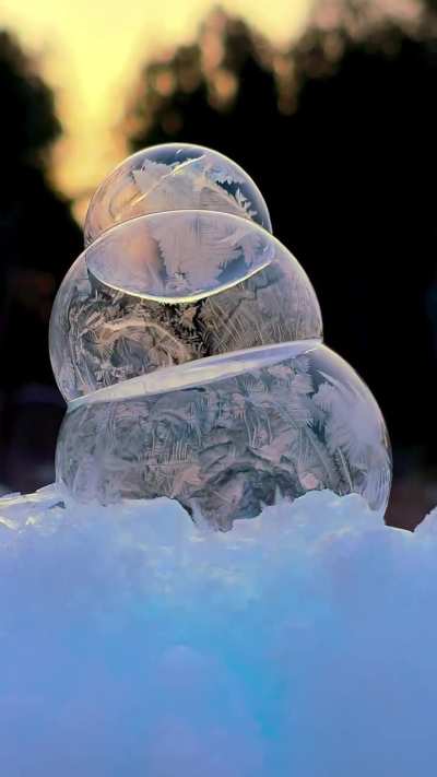 Soap bubbles stacked like a snowman freezing in the cold