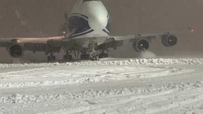 Video of B747-400F taxiing to the gate during a blizzard.