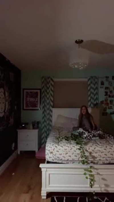 Girl tries doing a handstand on her bed with a low hanging ceiling light