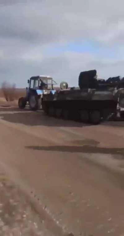 Ukrainian tractor taking a Russian MT-LB.
