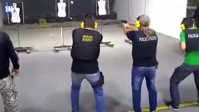 Police instructor walking in between live fire during shooting practice in Brazil.