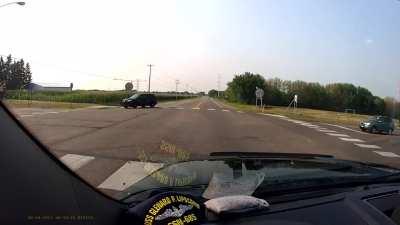 Idiot runs stop sign in front of police officer. Caught on camera by my dad.