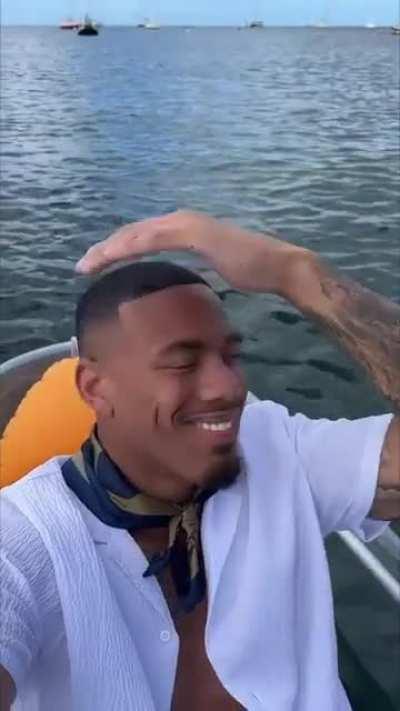 the object in my backpack - black guy filming himself on boat and smiling at camera