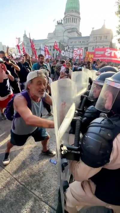 El destape y los medios de comunicación preparan una actuación de un manifestante siendo reprimido por la policía.