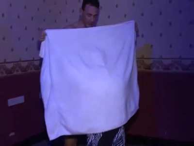 Cute middle aged woman follows Jeff onstage and plays with his cock behind the towel.