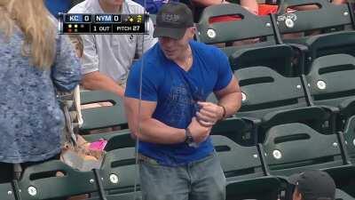 In 2013 this fan at a Mets game attempts to open a water bottle