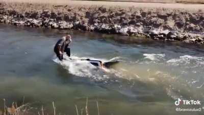 Guy floats down a creek on the roof of an SUV that he apparently just purchased a week prior