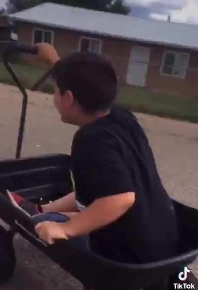 A young kid filming another kid trying to Tokyo Drift a wagon for a Viral Video.