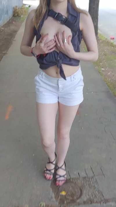 Letting her tits breathe while walking out in the streets