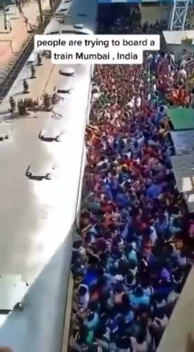 People in Mumbai trying to board a train.