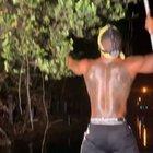 catching an iguana from a tree with his bare hands