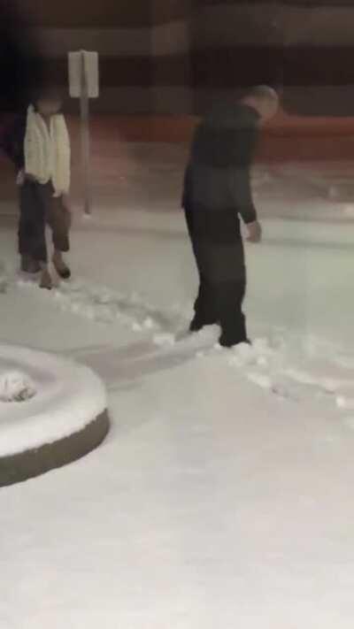 Husband clearing the snow path for his wife