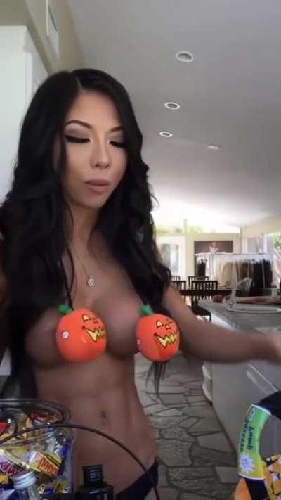 Sexy Asian with fake tits eating candy and taking shots