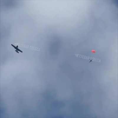 A Yak-52 sports and training aircraft hunts Russian UAVs in the sky of Odesa. The drone has deployed its parachute after being shot down.