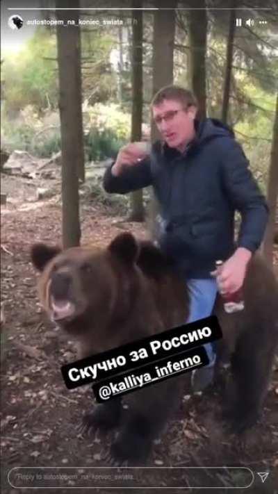 Russian man drinking vodka while riding a bear