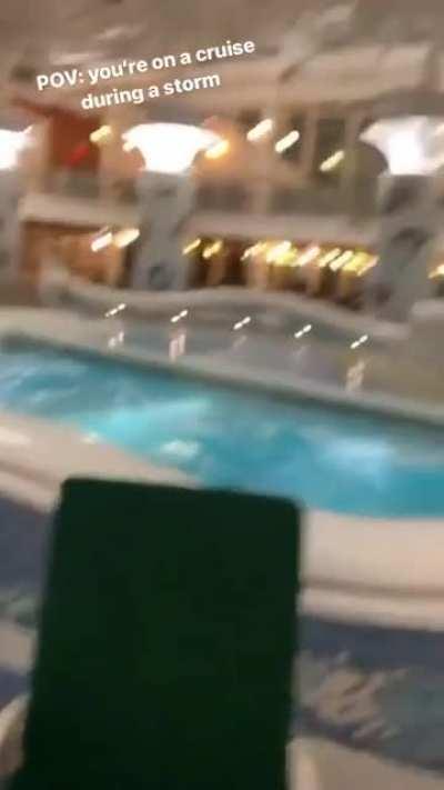 Guests sitting at the pool on a cruise during a storm