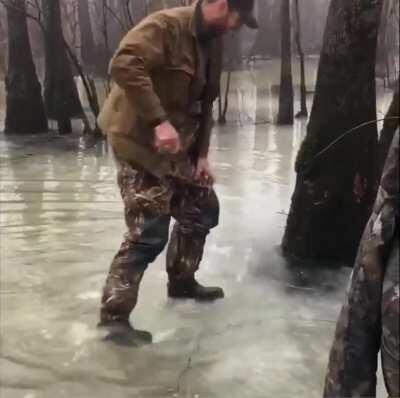 Duck hunter goes to get his gun by the tree