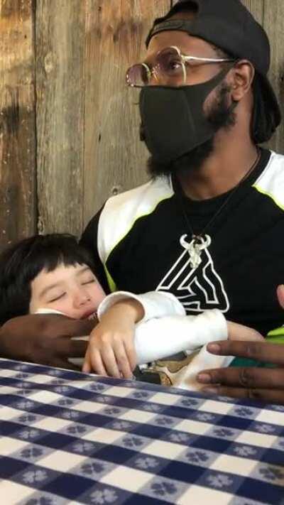 A regular customer at waiting on his takeout order at Chinese restaurant offers to rock toddler to sleep as her parents get slammed during dinner rush.