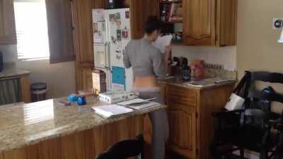 This man catching his wife dancing in the kitchen.