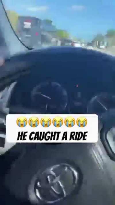 Man holds onto moving vehicle