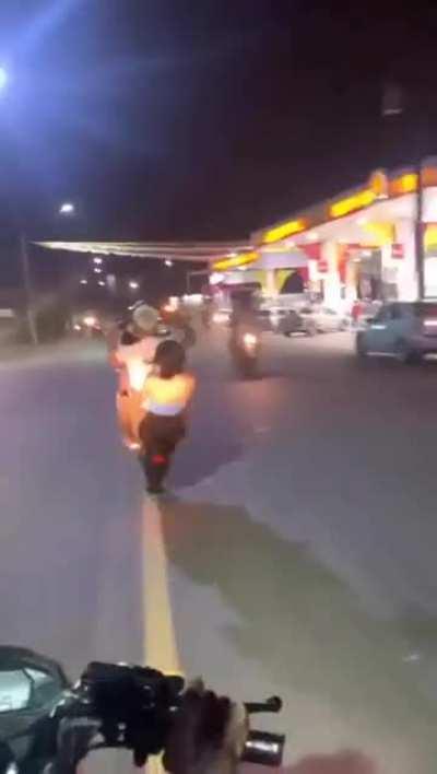 Couple performing dangerous stunts while riding a bike