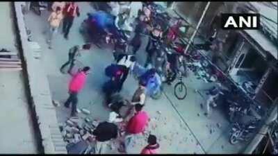 An under-construction pillar in a market in Rajasthan, India collapses on a pedestrian passing by from below leaving him with serious injuries.